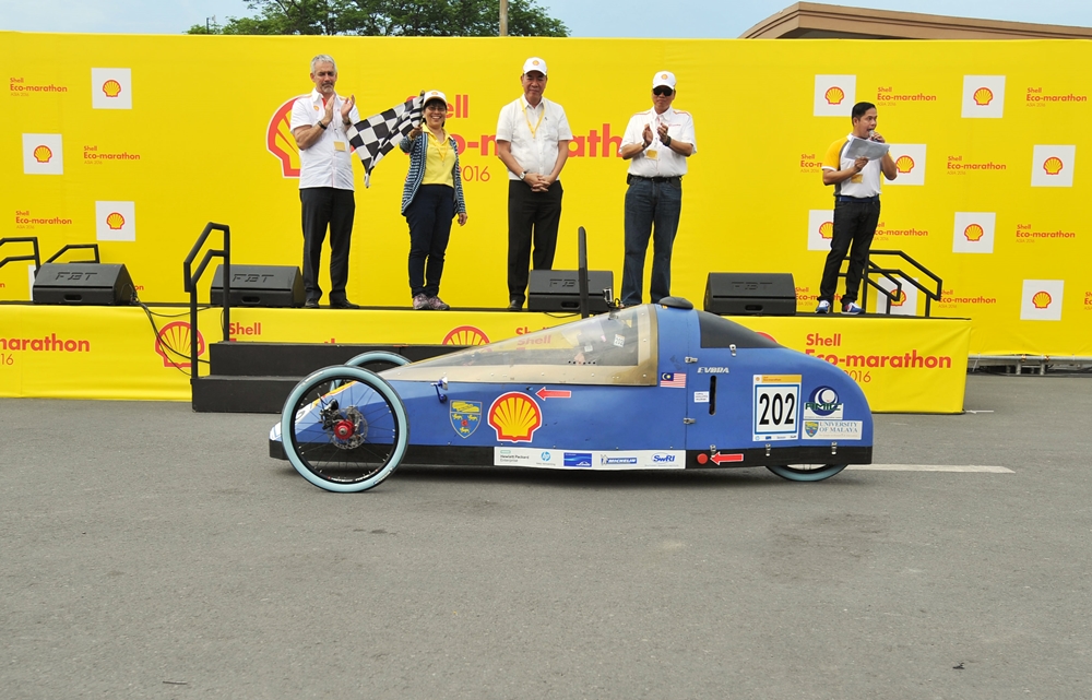 Simon Henry, Chief Financial Officer of Royal Dutch Shell, left, participates in the opening ceremony as the Honorable Zenaida Mondsada waves the checkered flag during day two of the Shell Eco-marathon Asia, in Manila, Philippines, Friday, March 4, 2016. (Jinggo Montenejo/AP Images for Shell)