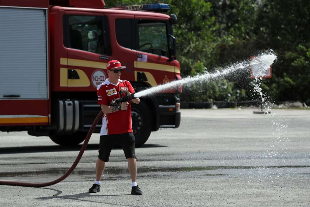 NEGRI SEMBILAN, MALAYSIA - SEPTEMBER 28: Kimi Raikkonen of Finland and Shell Ferrari uses a power water hose to extinguish a fire during a firefighter drill during the Shell V-Power Job Swap Asia on September 28, 2016 in Senawang, Negri Sembilan, Malaysia. (Photo by Stanley Chou/Getty Images for Shell) *** Local Caption *** Kimi Raikkonen