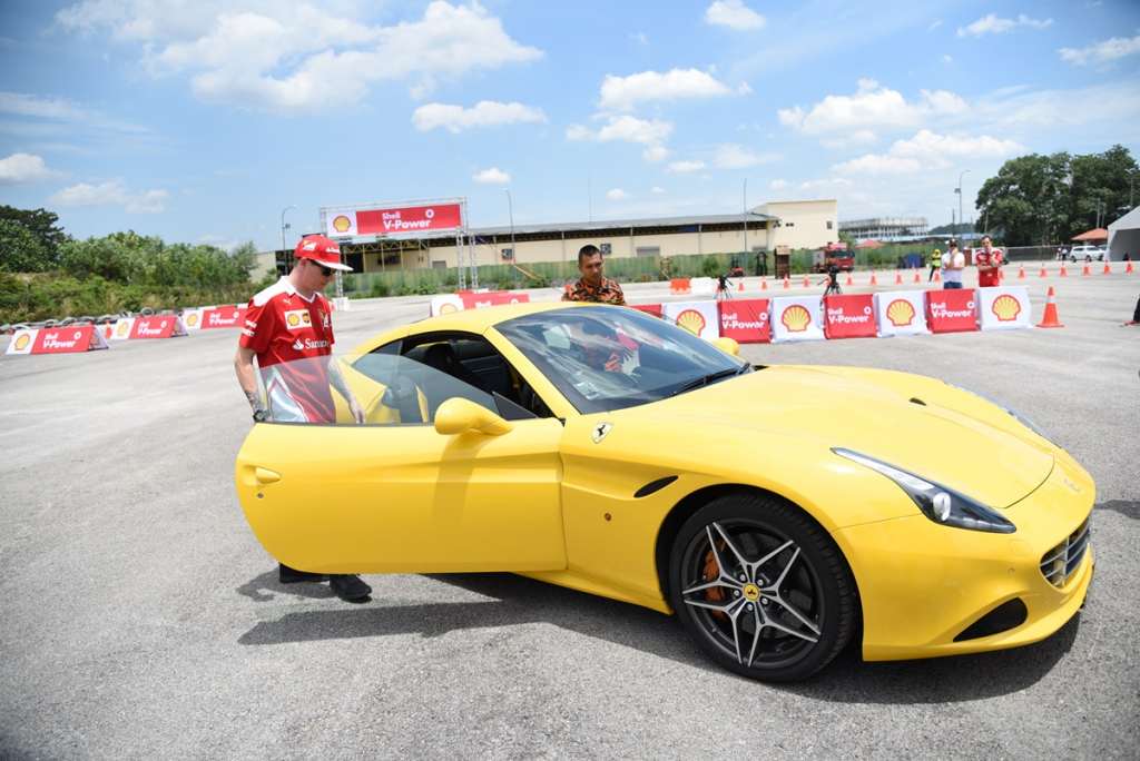 7. Scuderia Ferrari driver Kimi Räikkönen hops into a Ferrari California T with fireman Mohd Uzair Abdullah during the Shell V-Power Job Swap